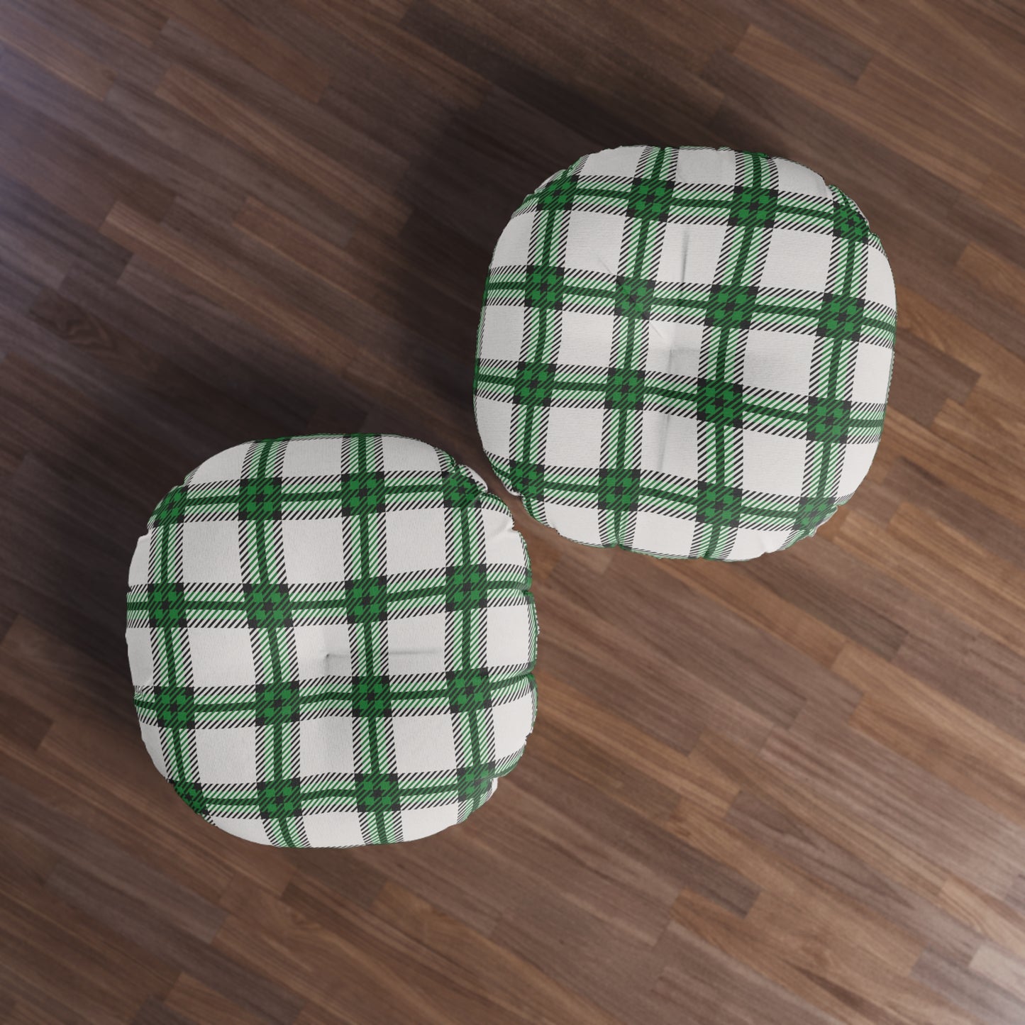 Two green and white checkered cushions on a wooden floor.