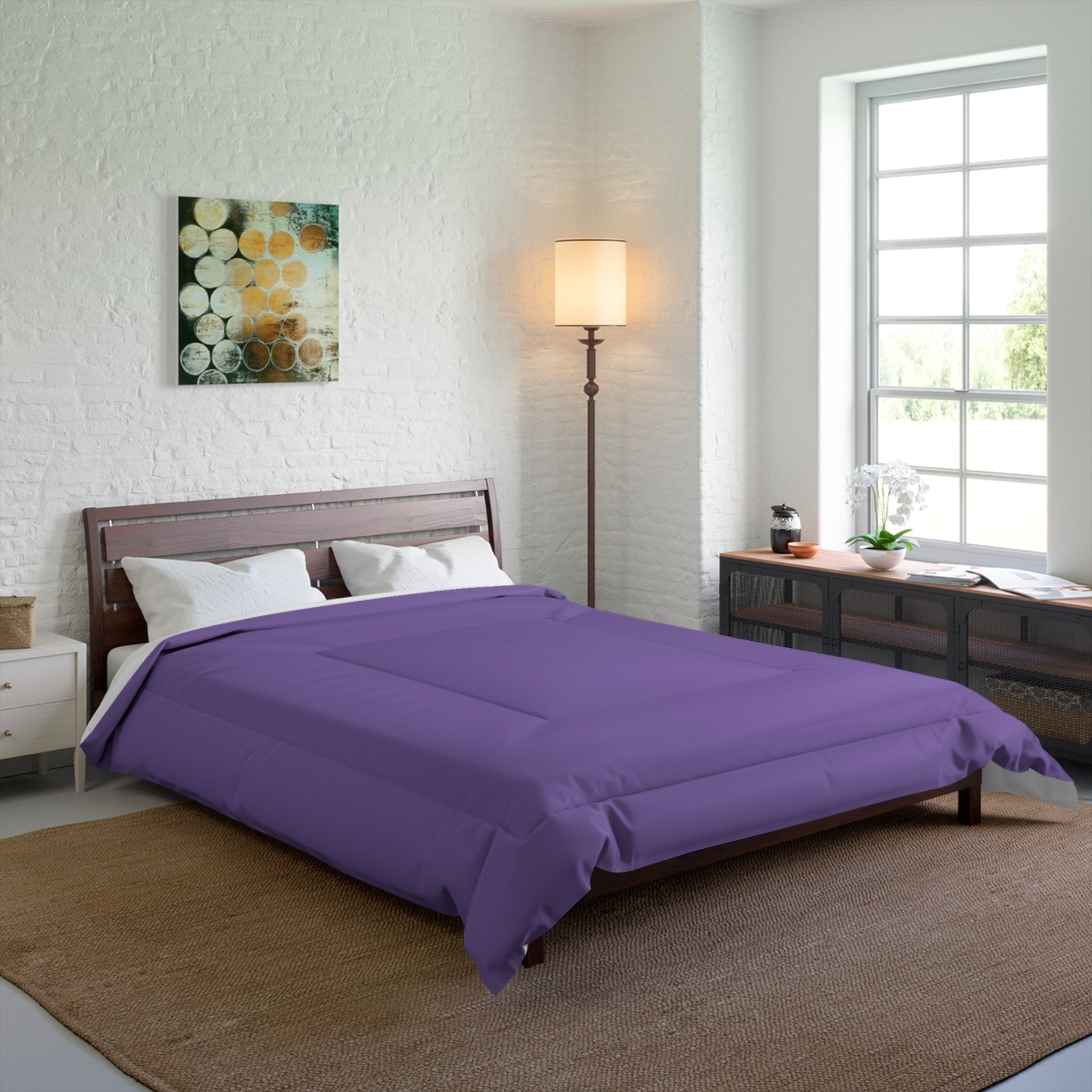 Bedroom with purple comforter on a bed, lamp, and window.