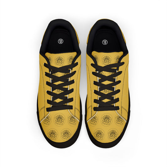 Yellow sneakers with black floral patterns on a white background