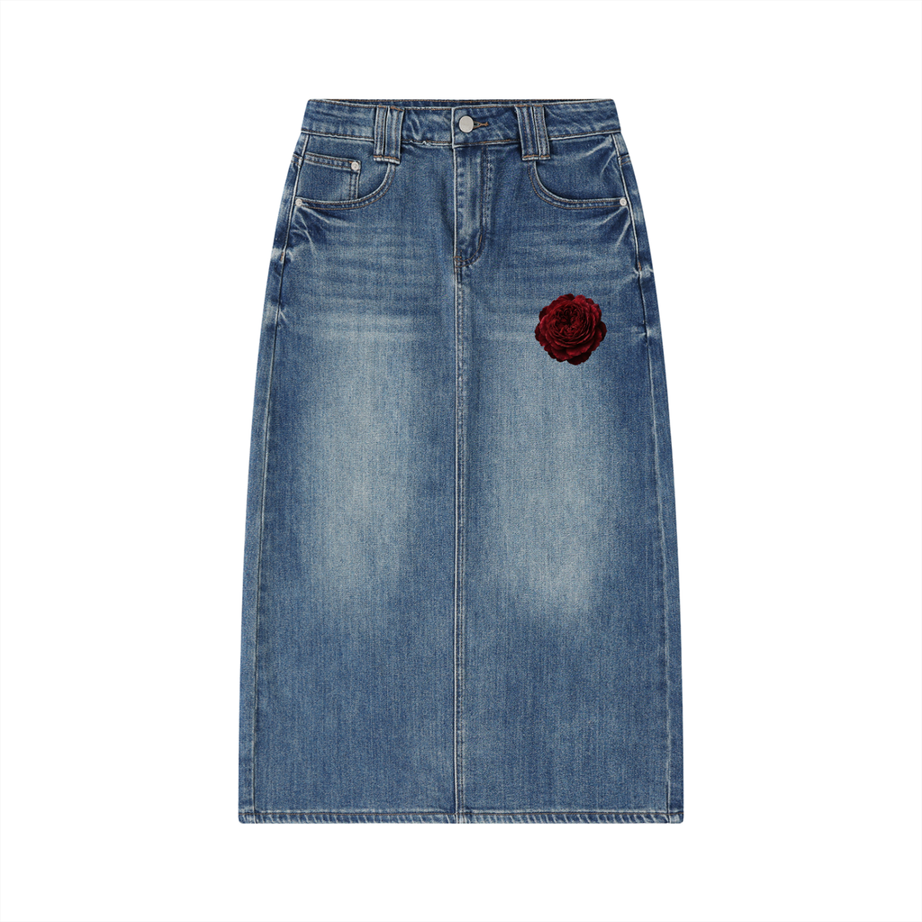 A blue denim midi skirt with a single red rose patch on the left front pocket, shown flat against a solid white background.