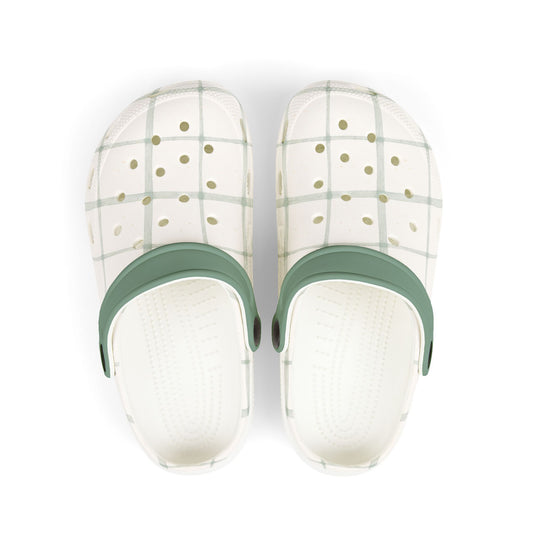 Pair of white slippers with green straps on a white background